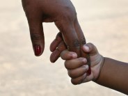 black mothers hand holding childs hand